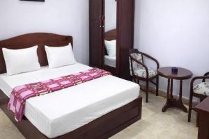 a bedroom with a bed and a table and a chair at Hằng Hoa Hotel Đồng Nai in Dĩ An