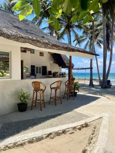 a resort with chairs and a bar on the beach at Surya Beach Resort Palawan in Aborlan