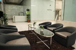 a waiting area with chairs and tables in a lobby at Cormar Residences Kuala Lumpur in Kuala Lumpur