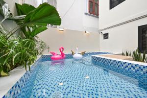 two pink flamingos in a swimming pool in a house at Soi by La Doma Express in Ho Chi Minh City