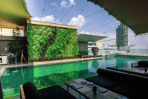 a large swimming pool with a green wall at Sankara Nairobi, Autograph Collection in Nairobi