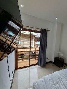 a bedroom with a bed and a large window at Serena Rooms in El Nido