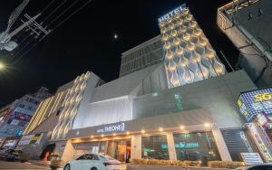 a building with a car parked in front of it at INCHEON AIRPORT HOTEL THE ONe in Incheon