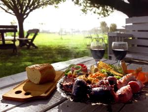 a plate of food on a table with two glasses of wine at Pampas del Sur - Hotel de Campo - Cañuelas in Cañuelas
