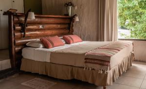 a bedroom with a bed with two pillows and a window at Pampas del Sur - Hotel de Campo - Cañuelas in Cañuelas