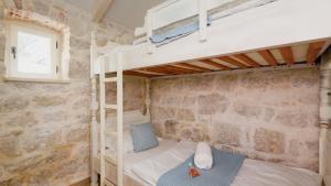 a bedroom with two bunk beds and a window at Villa Mendula -Orebic by Villas Guide in Orebić