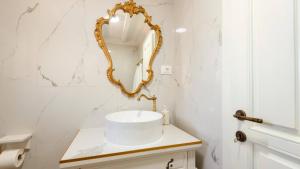a white bathroom with a gold mirror on the wall at Villa Mendula -Orebic by Villas Guide in Orebić