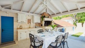 a kitchen with a table with chairs and a blue door at Villa Mendula -Orebic by Villas Guide in Orebić