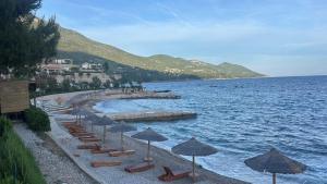 a row of chairs and umbrellas on a beach at Villa Mendula -Orebic by Villas Guide in Orebić