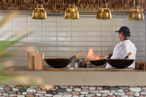 a chef preparing food in bowls on a counter at Atlantica Dreams Resort in Gennadi +214 photos