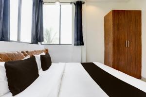 a bedroom with a bed with a black and white blanket at Hotel O MP Nagar Near Rachna Tower in Bhopal