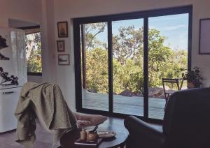 a living room with a large window looking out at the water at The Ridge Retreat on Litchfield in Rum Jungle Station