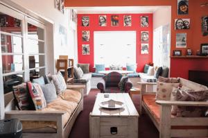 a living room with red walls and couches at Hermanus Backpackers & Budget Accommodation in Hermanus