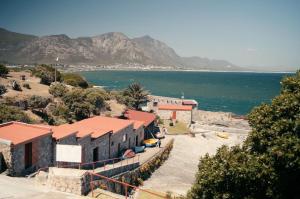 a building on the shore of a beach next to the water at Hermanus Backpackers & Budget Accommodation in Hermanus
