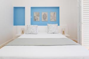 a bedroom with a large white bed with two pillows at Villa Mykonos in Cape Town