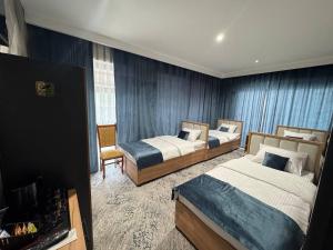 a hotel room with two beds and a chair at Best Guest House in Andizhan
