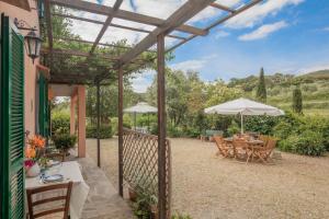 a wooden pergola with a table and umbrella at Appartamenti Quintavalle in Casa Marchetti