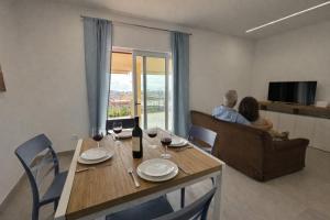 a man and woman sitting at a table with wine glasses at Home & Garden in Vico Equense