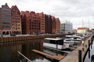 a group of boats docked in a river with buildings at Gdańsk Luxury Stay Jacuzzi in Gdańsk