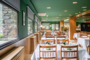 a dining room with white tables and chairs at Hotel Coray by Pierre & Vacances in Encamp