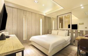 a bedroom with a large white bed and a desk at 대구 더스테이낭만 태전점 in Daegu