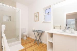a white bathroom with a sink and a toilet at Villa Mykonos in Cape Town