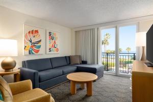 a living room with a blue couch and a table at Embassy Suites by Hilton Deerfield Beach Resort & Spa in Deerfield Beach