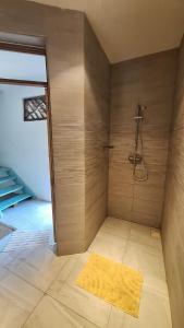 a bathroom with a shower with a yellow rug at Kipepeo Beach and Village in Dar es Salaam