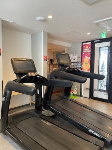 a gym with two treadmills in a room at Q FOX GMG HOTEL in Kutchan