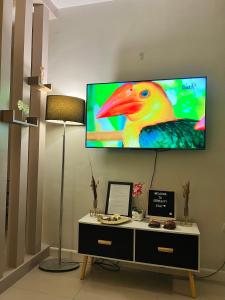 a television on a wall with a colorful bird on it at Serenity Stay in General Santos
