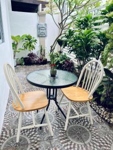 a glass table and two chairs on a patio at Serenity Stay in General Santos
