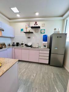 a kitchen with pink cabinets and a refrigerator at Serenity Stay in General Santos