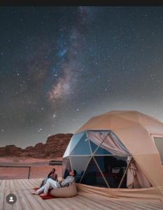 two people sitting in a tent under the stars at Wadi Rum Main Road Visitor Center in Disah +22 photos