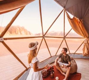 a man and a woman inside of a tent at Wadi Rum Main Road Visitor Center in Disah