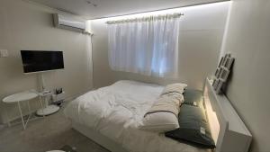 a small bedroom with a bed and a television at 모던한 스테이 in Samgong