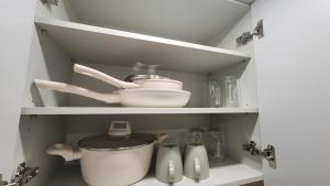 a cupboard with a pot and other kitchen utensils at 모던한 스테이 in Samgong +11 photos
