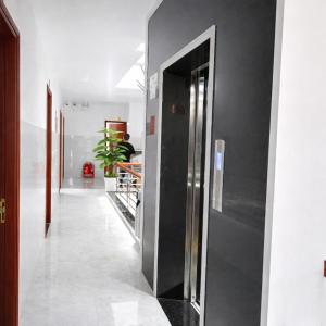 a hallway with a black refrigerator in a room at Bảo Di Sóc Trăng Hotel in Soc Trang