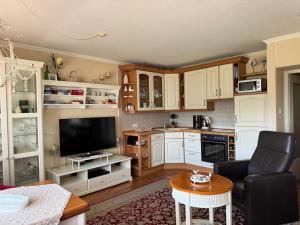a kitchen with white cabinets and a living room at Langeneß Whg 15 Strandtraum in Wyk auf Föhr