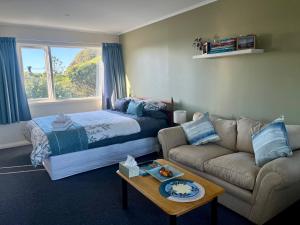 a living room with a bed and a couch at Makara Beach Escape in Wellington
