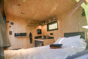 a room with a bed and a kitchen in a tiny house at Green&Tiny Spot Wolfenbüttel Okeraue - Sleep Space 1 in Wolfenbüttel