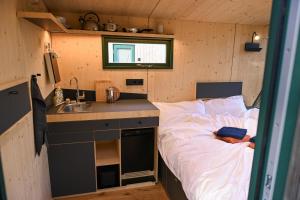 a small room with a bed and a sink at Green&Tiny Spot Wolfenbüttel Okeraue - Sleep Space 2 in Wolfenbüttel