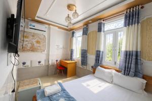 a bedroom with a bed and a desk and window at Lộc Duyên Motel Ninh Kiều in Cái Răng