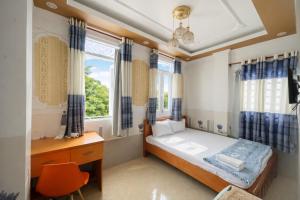 a bedroom with a bed and a desk and windows at Lộc Duyên Motel Ninh Kiều in Cái Răng