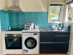 a kitchen with a washing machine and a sink at Makara Beach Escape in Wellington +6 photos