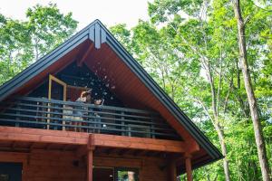 a group of people standing on the balcony of a tree house at LEVATA Nasu バレルサウナ付きログハウス BBQ可 1棟貸切 6名様まで同料金 in Nasu +56 photos