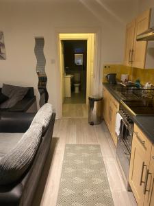 a living room with a couch and a kitchen at 4 Castle Walk in Stansted Mountfitchet