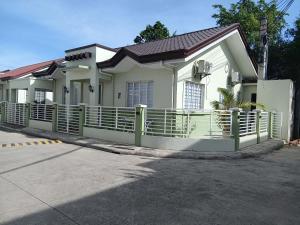 a white house with a fence in front of it at Casathea Hometel Cebu in Talisay