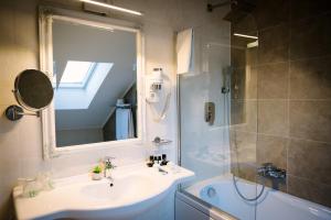 a bathroom with a sink and a shower with a mirror at Hotel-Restaurant La Belle Epoque in Petroşani +53 photos