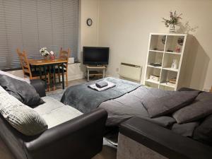 a bedroom with a bed and a couch and a table at 4 Castle Walk in Stansted Mountfitchet