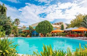 a swimming pool at a resort with orange umbrellas at Paradise Station 3 Garden Boracay Resort by JustGoFun in Boracay